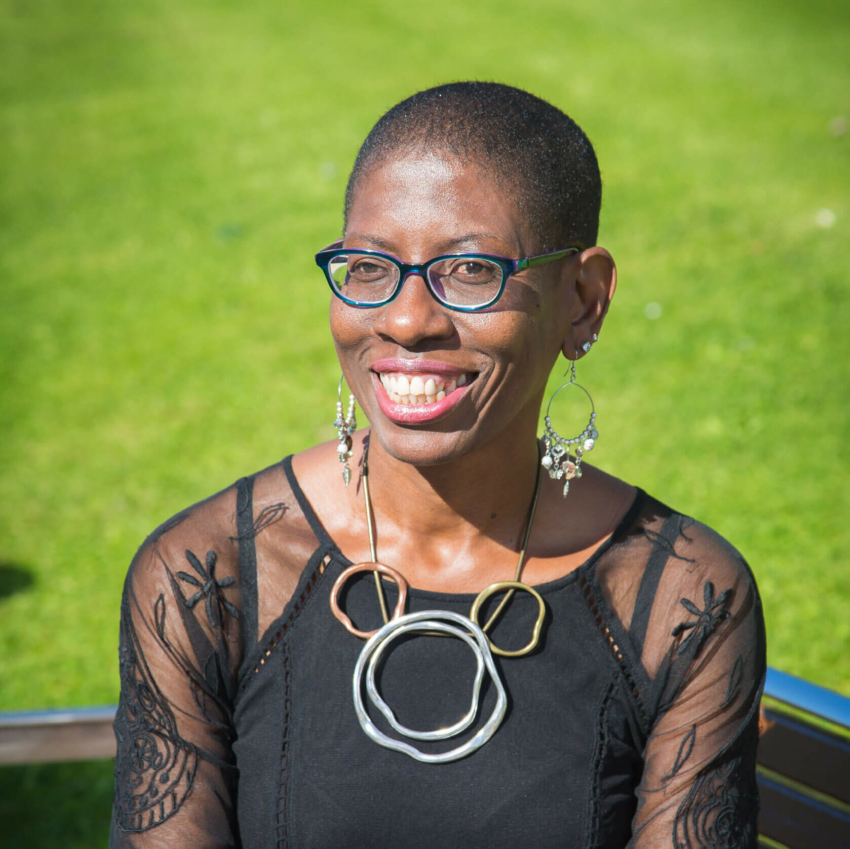 Portrait image of Donna Chambers sat outside on a bench